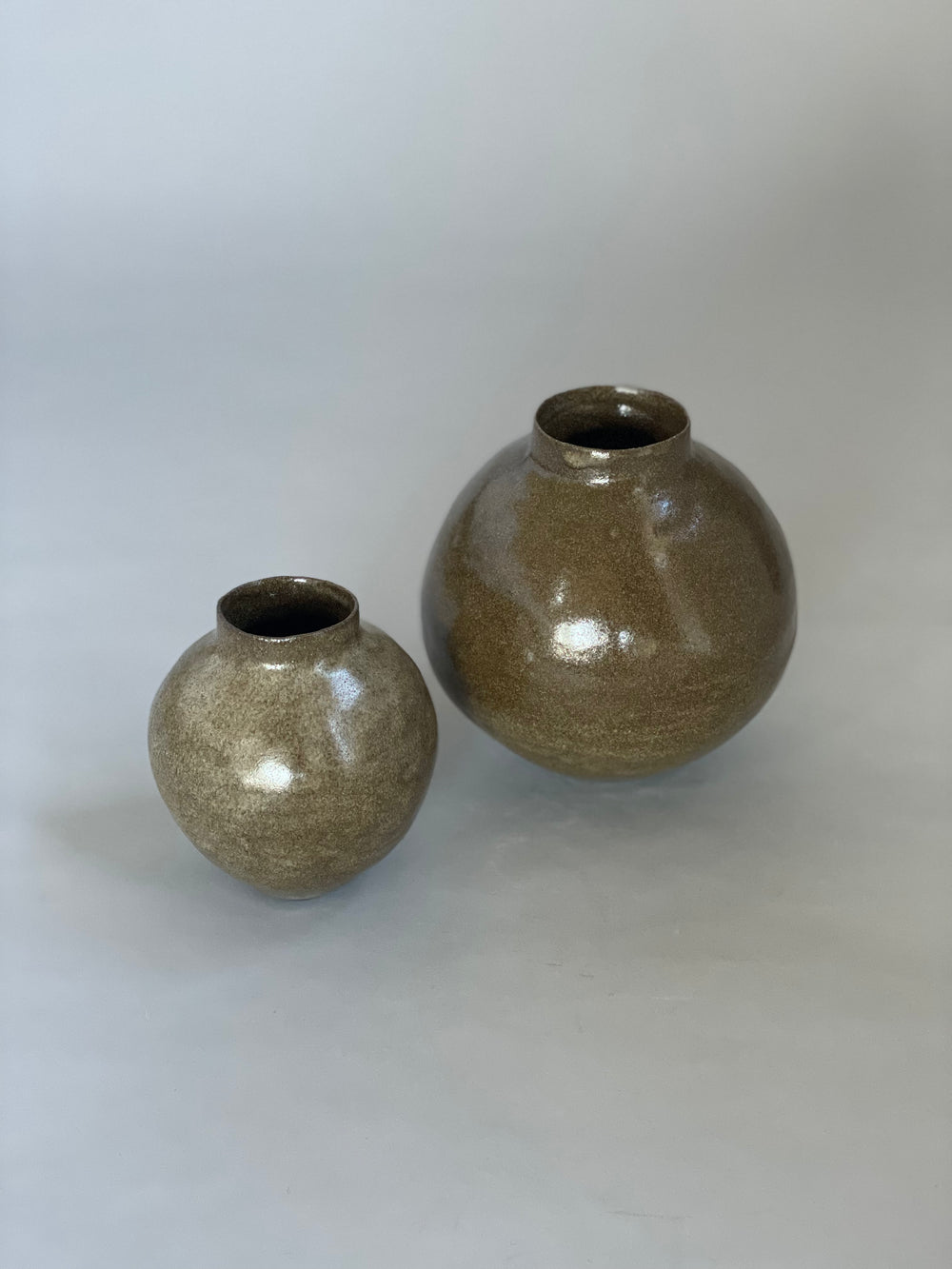 Side view of an organic ceramic vessel with a simple form and earthy tones.