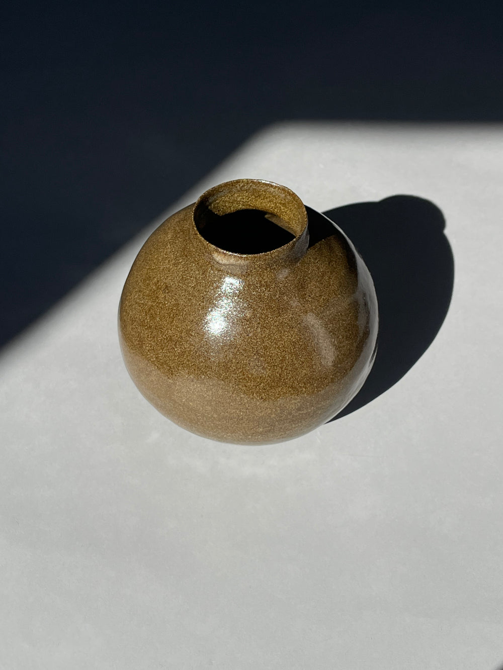 Top-down view of a handmade ceramic vase, emphasizing its earthy glazed finish and unique craftsmanship.