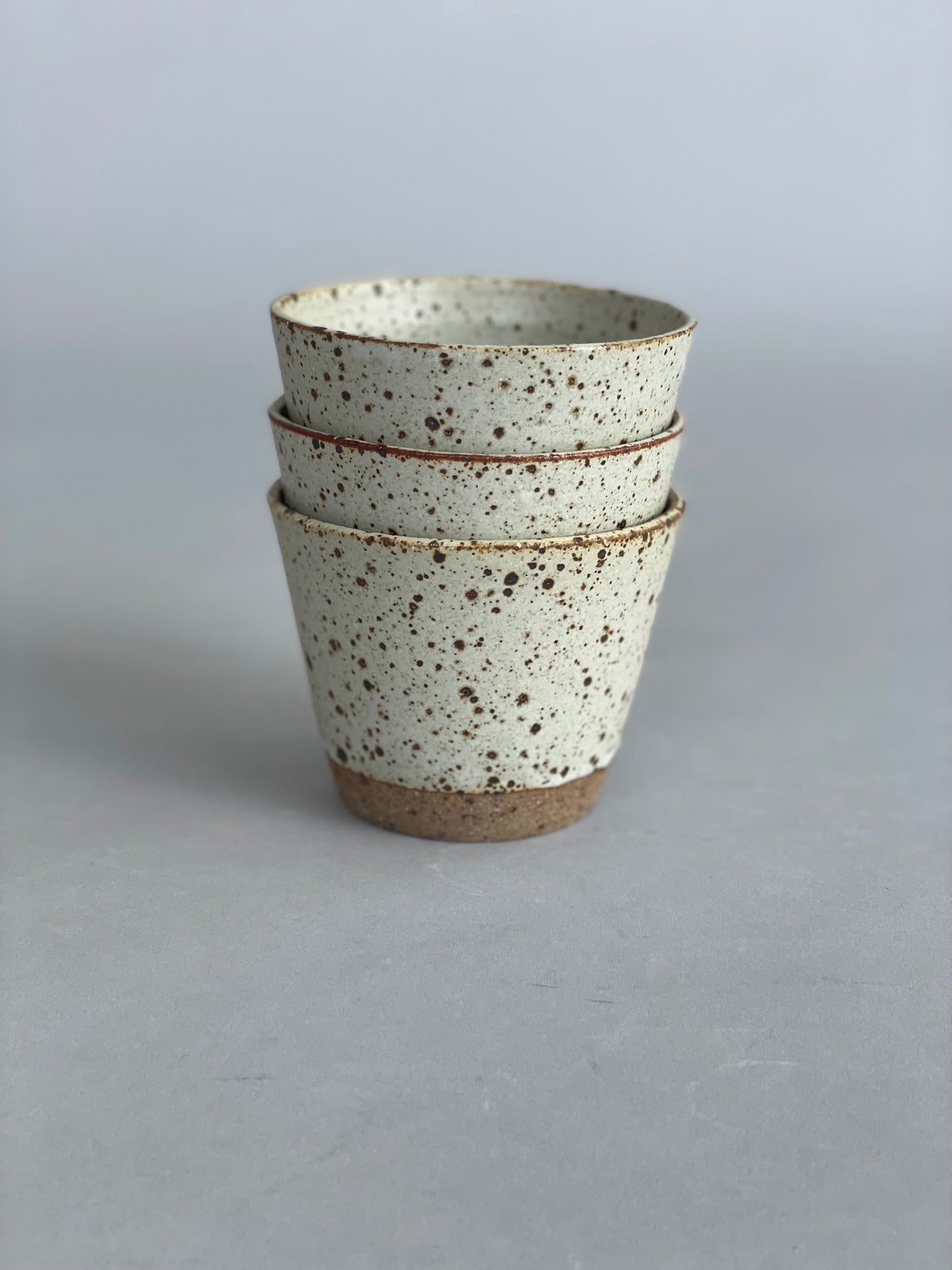 Side view of a stack of tumblers, emphasizing their consistent yet unique artisanal design.