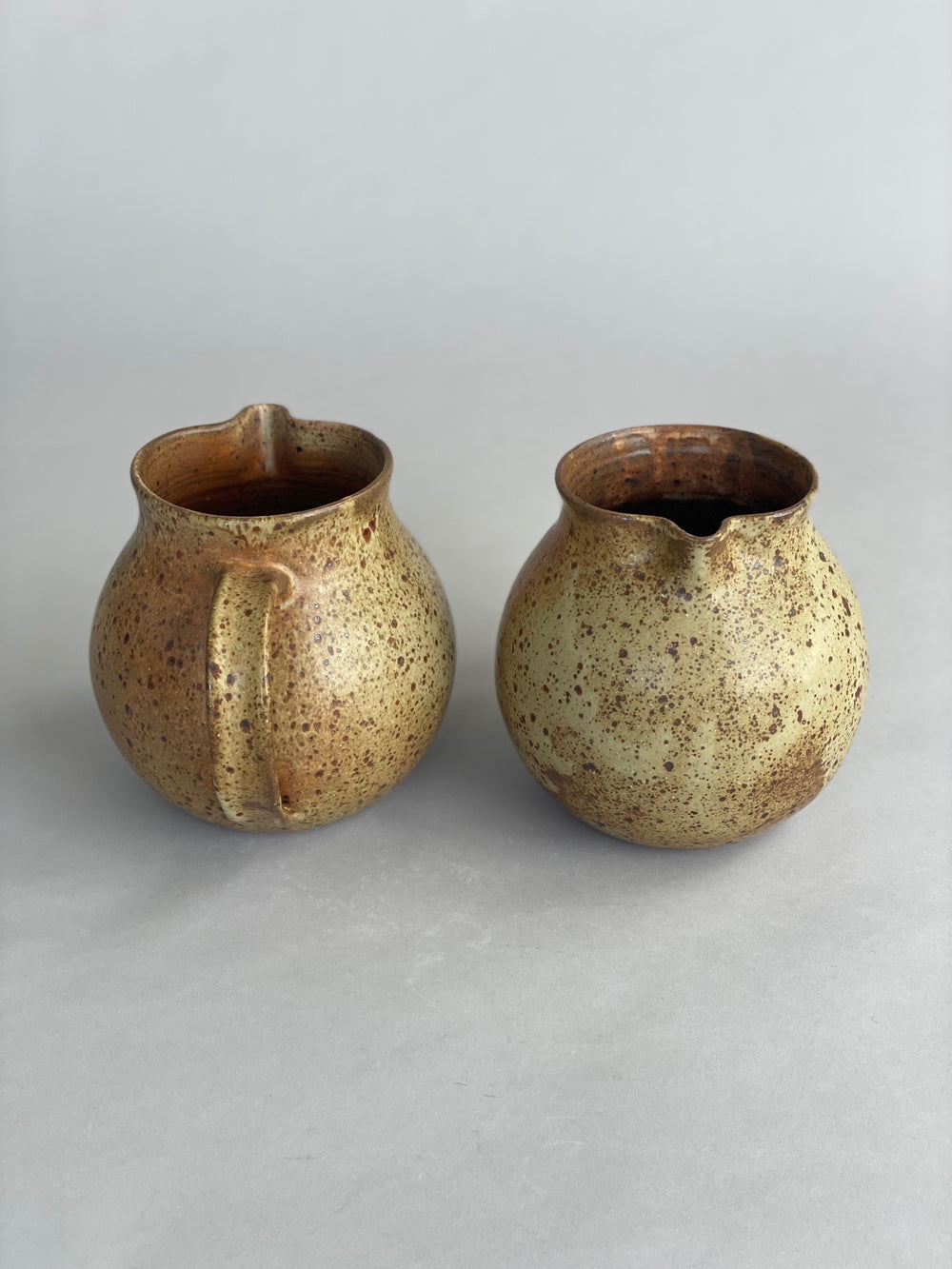 Side view of a speckled stoneware jug, perfect for serving water at the table or in the kitchen.