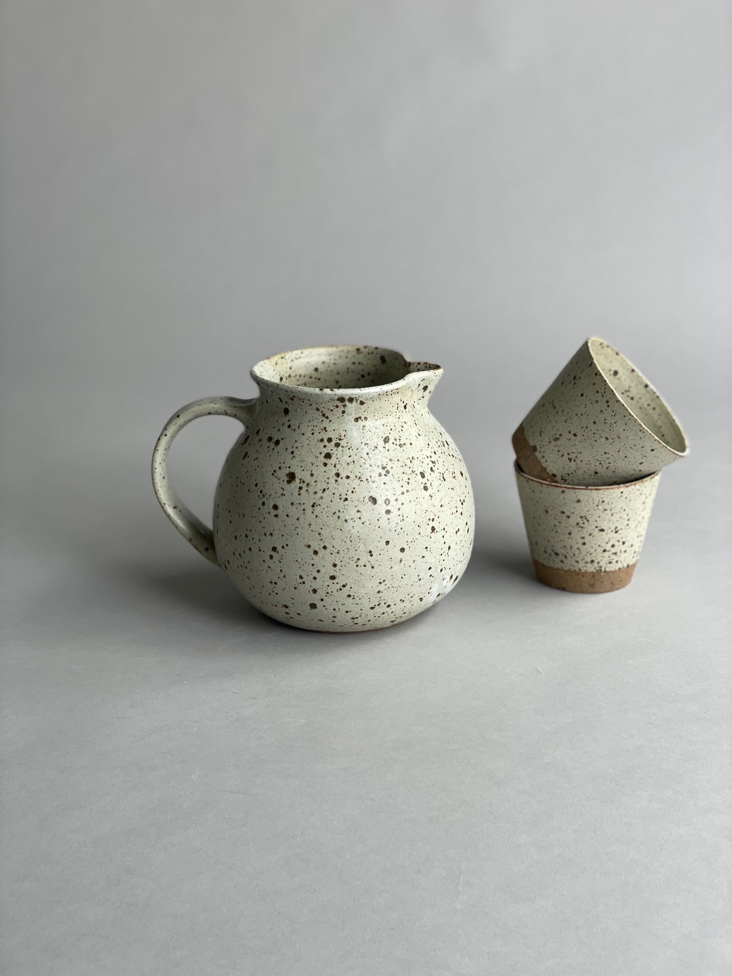 A group of handmade pieces from Larissa Milsum arranged side by side, showing variations in size and glaze.