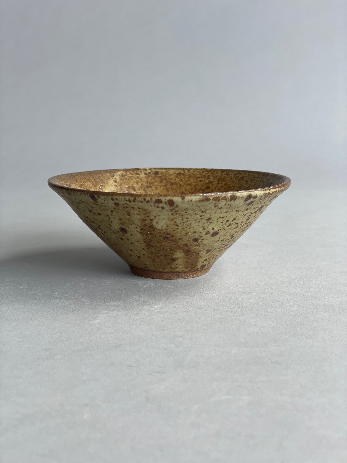 Side view of a handmade ceramic bowl, highlighting its smooth finish and minimalist design.
