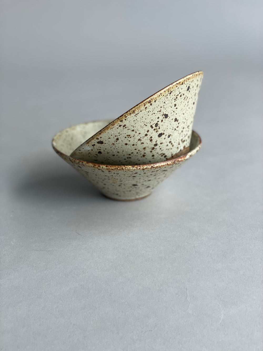 Close-up of the speckled glaze on a small ceramic bowl, emphasizing its modern and unique design.