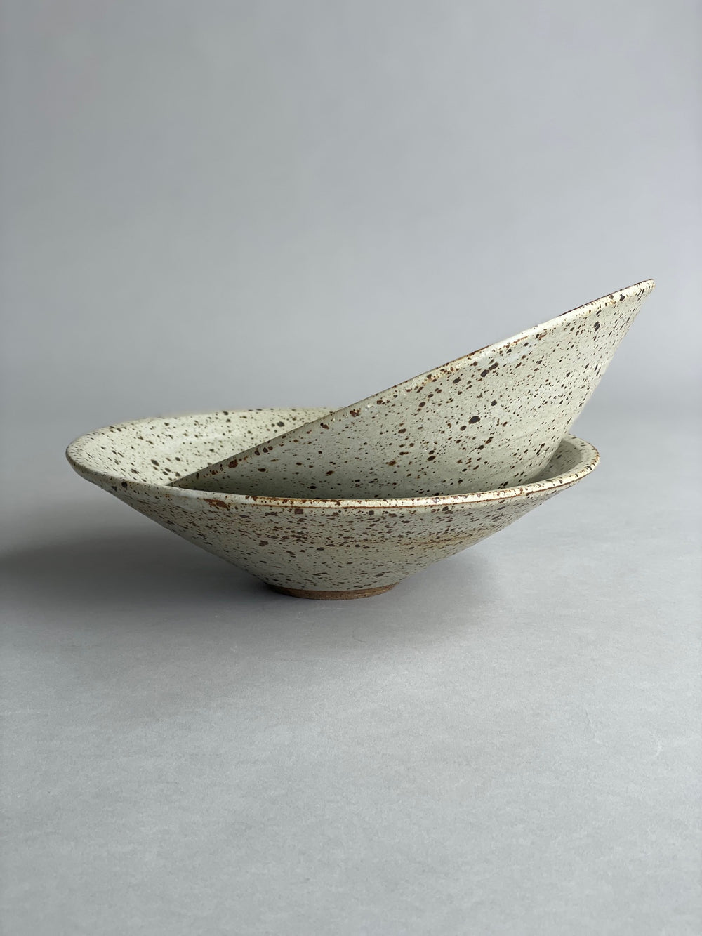 A group of ceramic bowls arranged on a table, showing slight variations in size and glaze due to their handmade nature.
