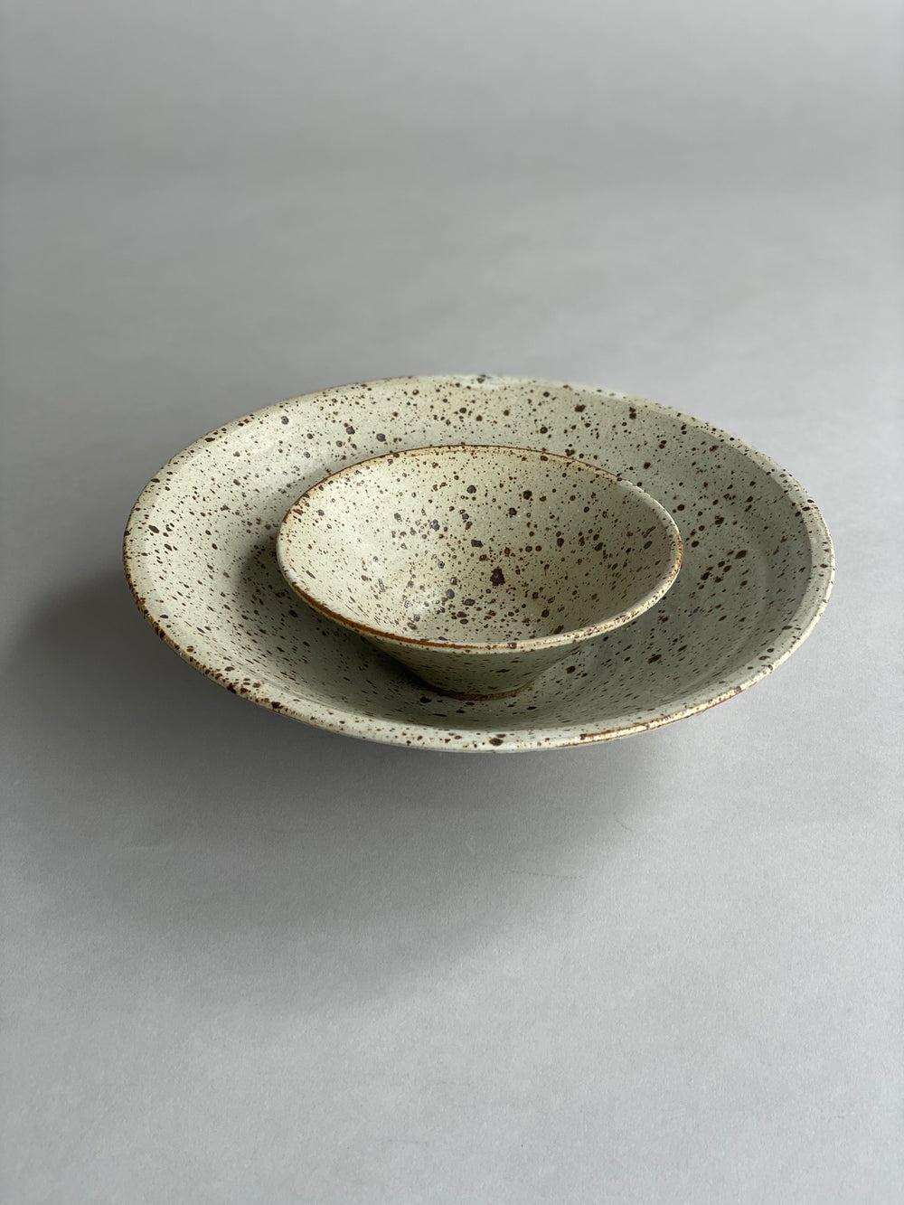 Close-up of the speckled glaze on a small ceramic bowl, emphasizing its modern and unique design.