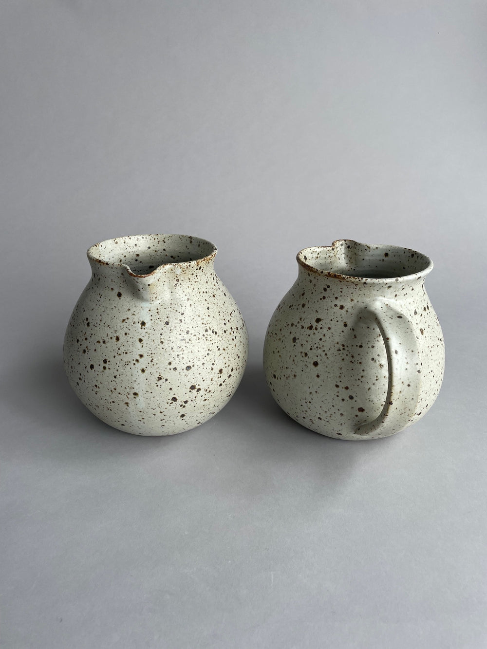 Side view of a speckled stoneware jug, perfect for serving water at the table or in the kitchen.