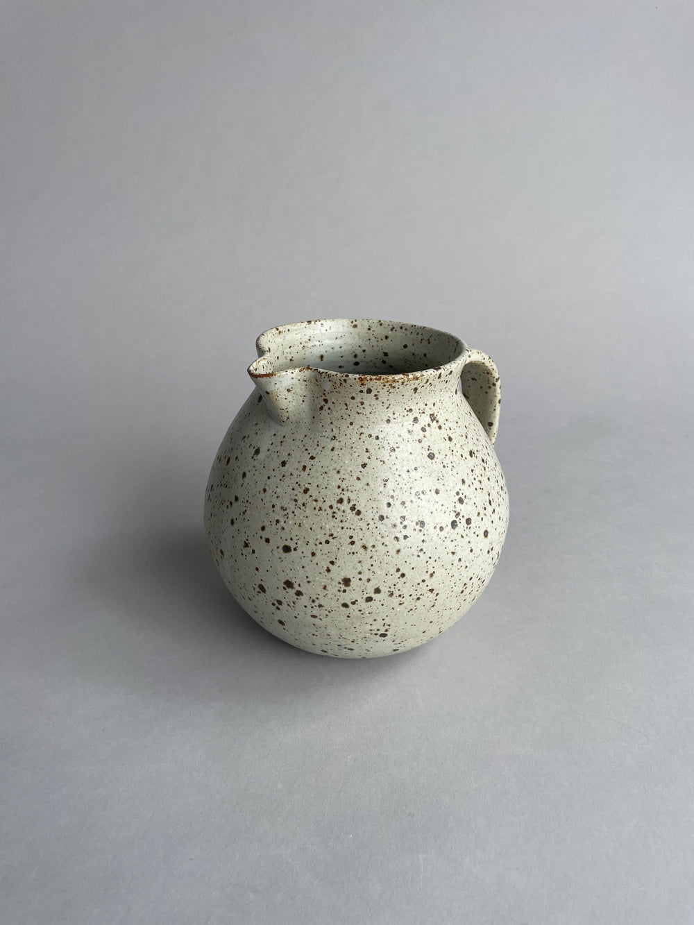 Close-up of a ceramic jug by Larisa Milsum, showcasing its unique texture and artisanal craftsmanship.