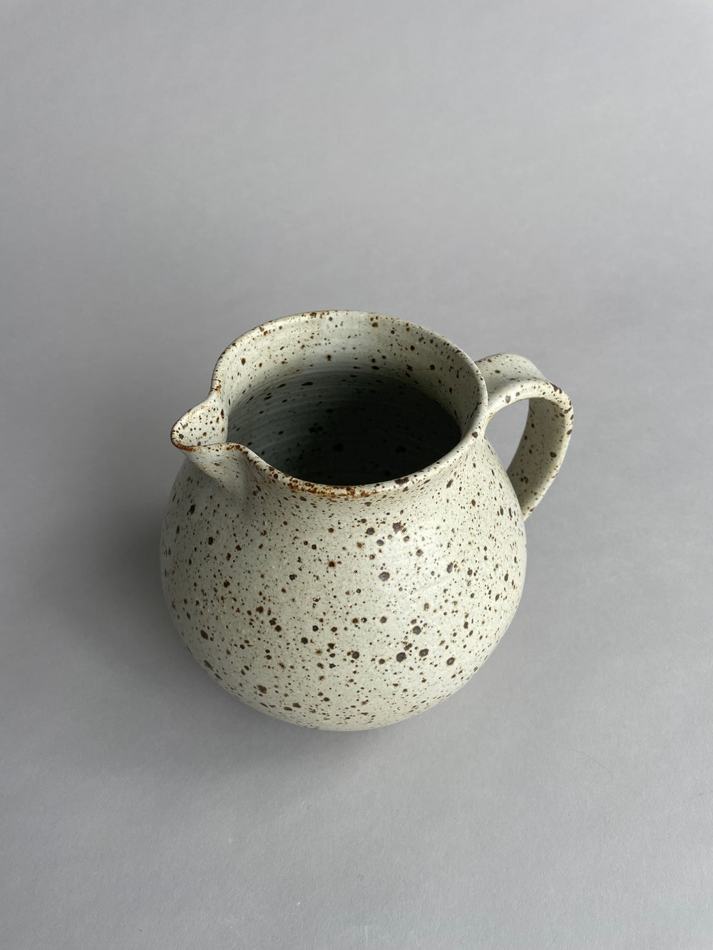 Close-up of a ceramic jug by Larisa Milsum, showcasing its unique texture and artisanal craftsmanship.