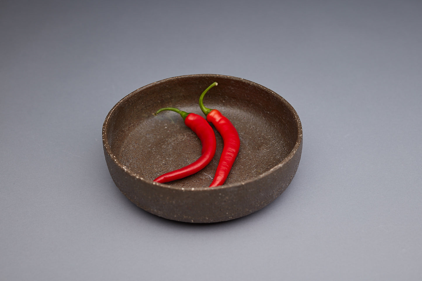 Unique textured bowls handmade by potter Kirsten Dryburgh. Two Chillis are in the bowl