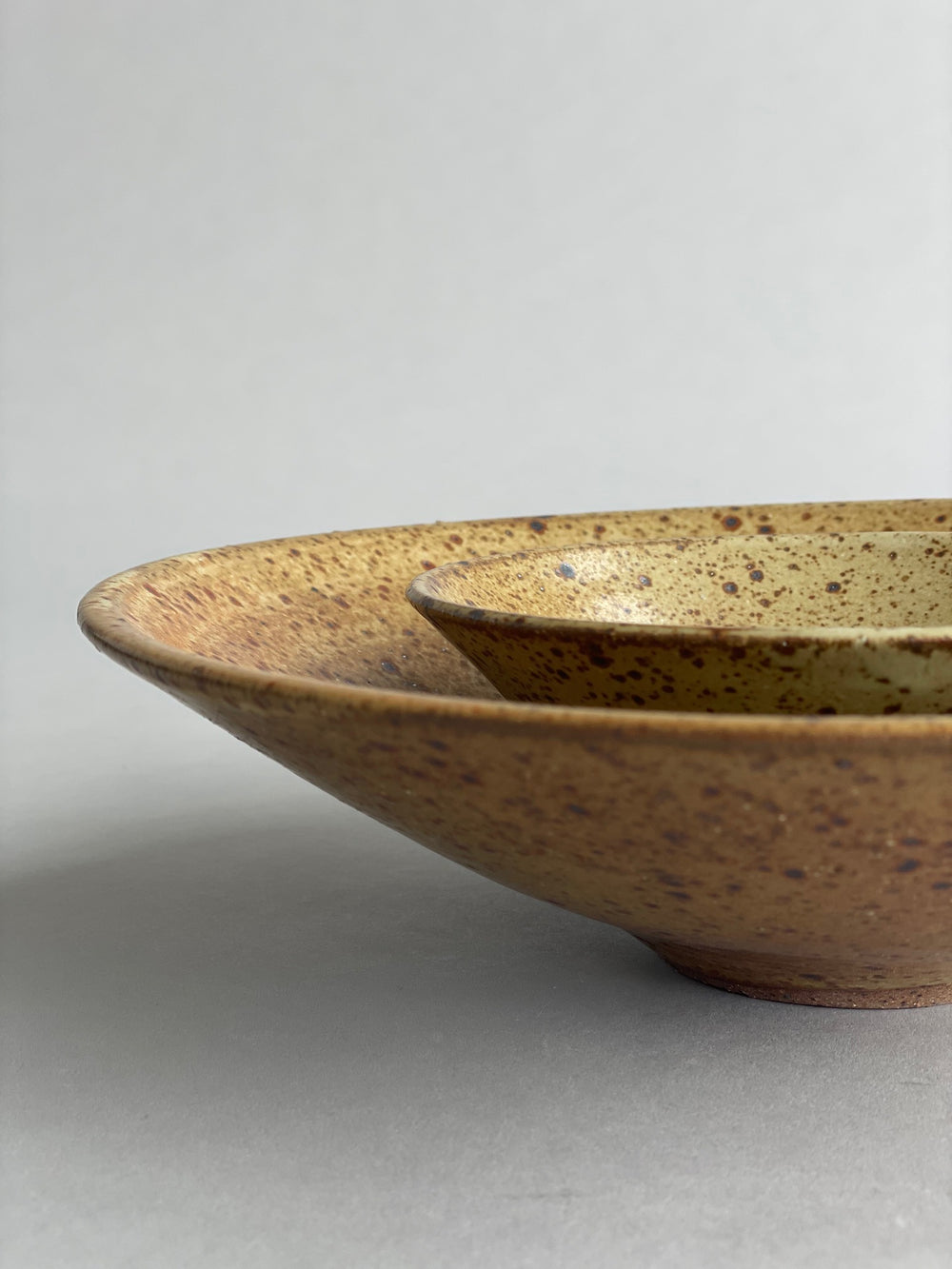 Close-up of the rim of a ceramic bowl, revealing the intricate speckled details of the glaze.