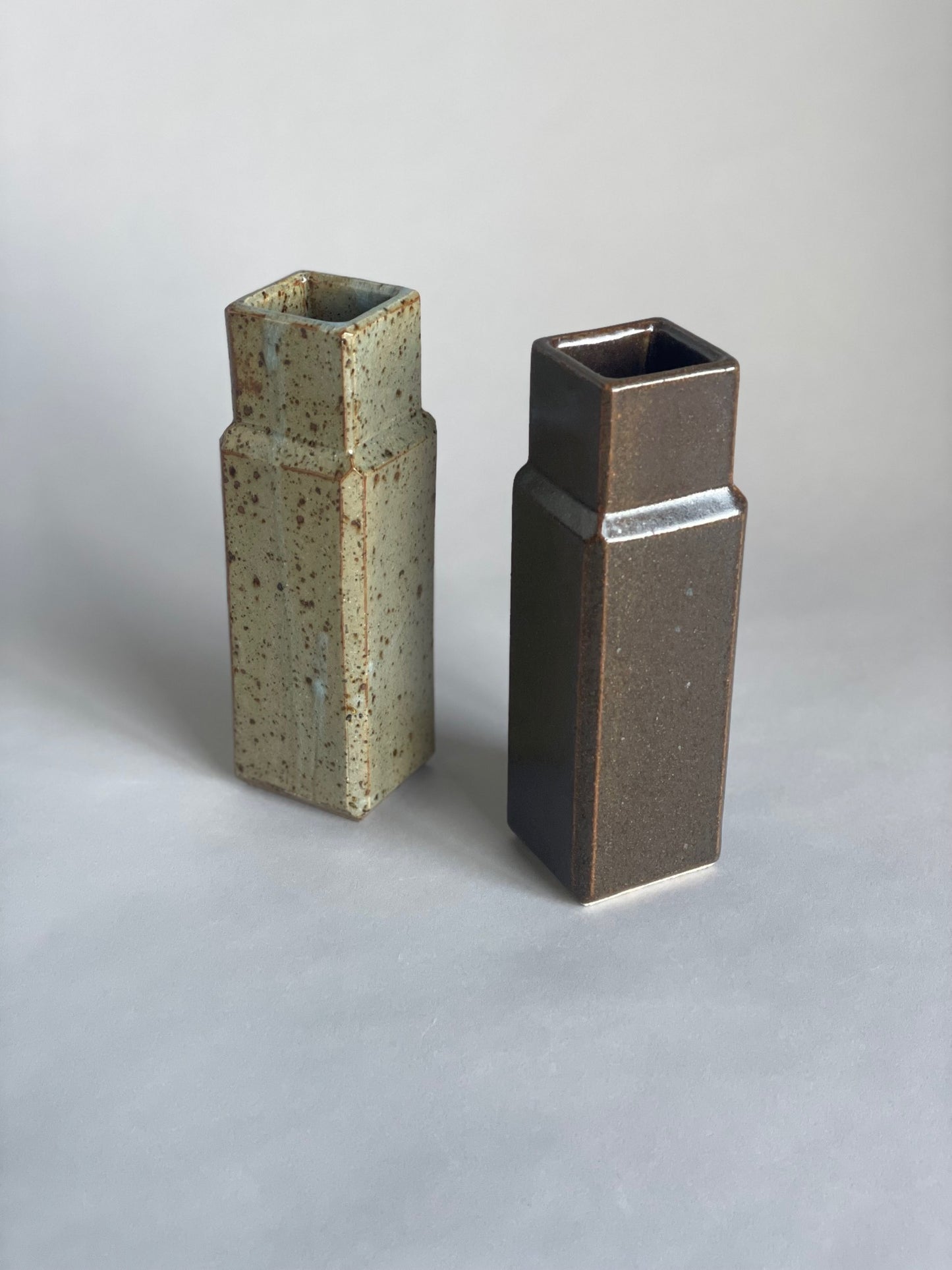 Two column vases by Misma Anaru in an estruscan blue glaze and brown wairepo glaze.