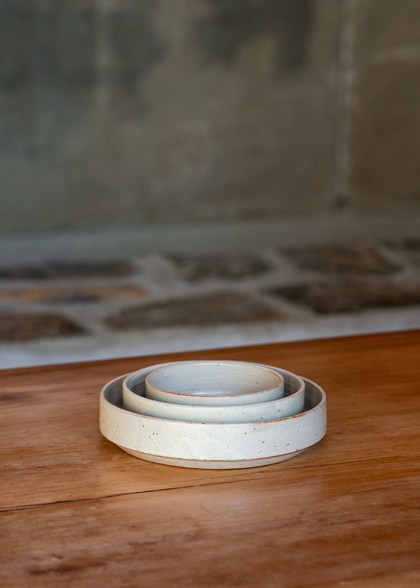 Group of monochromatic platesarranged together, emphasizing their textured stone-like surfaces.