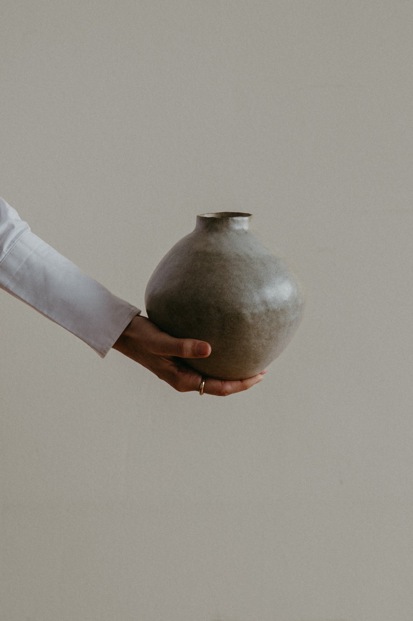 Handmade ceramic vase with a warm earthy glaze and dark clay base, showcasing its unique texture.