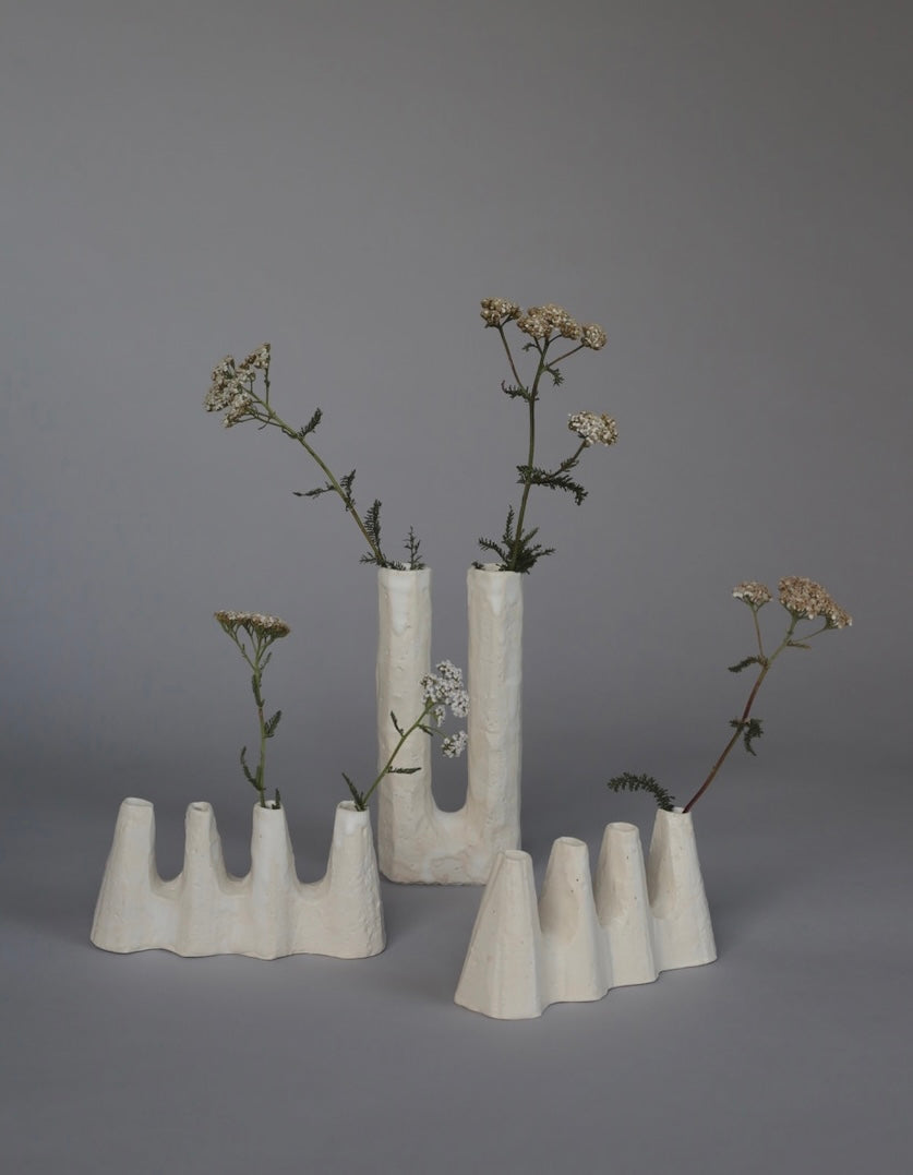 A group of Kirsten Perry ceramic vases, each with unique textures and subtle variations in form and finish.