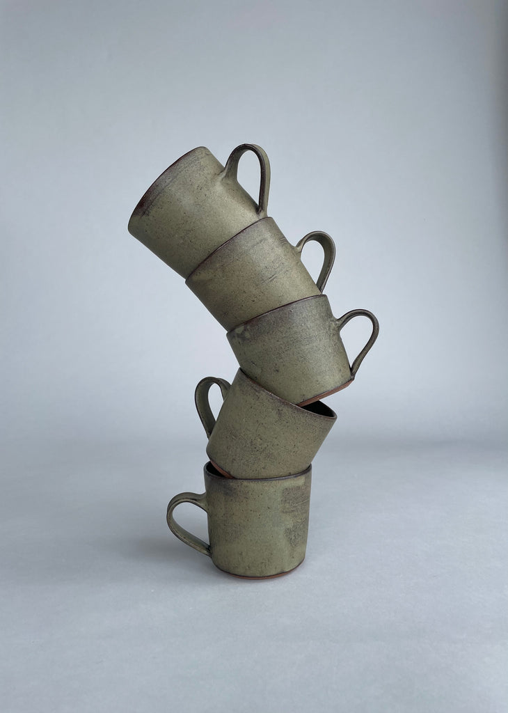 A stack of stunning handmade green cups made for Situ Studio by Wellington potter, Zoe Isaacs.