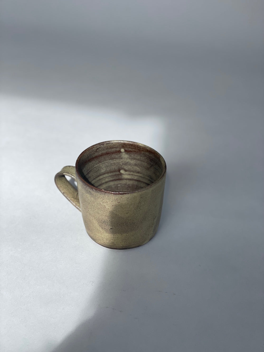 Handmade green cups made for Situ Studio by Wellington potter, Zoe Isaacs.