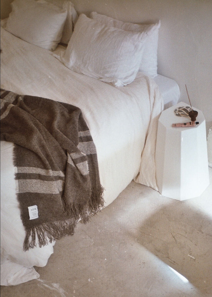 Soft luxurious wool throw made in New Zealand and designed by Situ Studio. A natural dark grey with an ecru stripe making this blanket a classic to  style your home with. Made to last and to use everyday.
