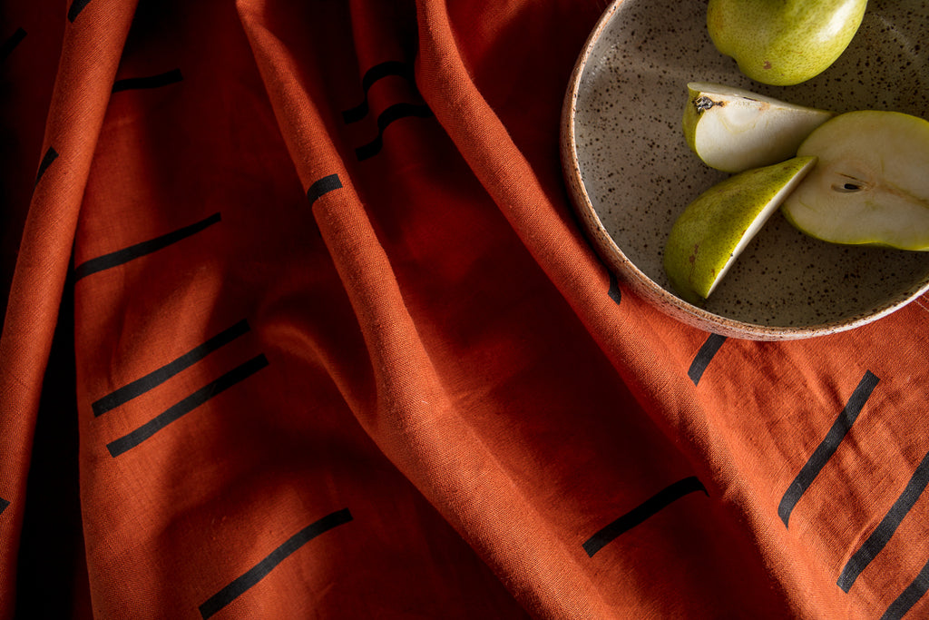 A clay coloured heavy linen throw with a screen printed design by Situ Studio. Made in new Zealand.