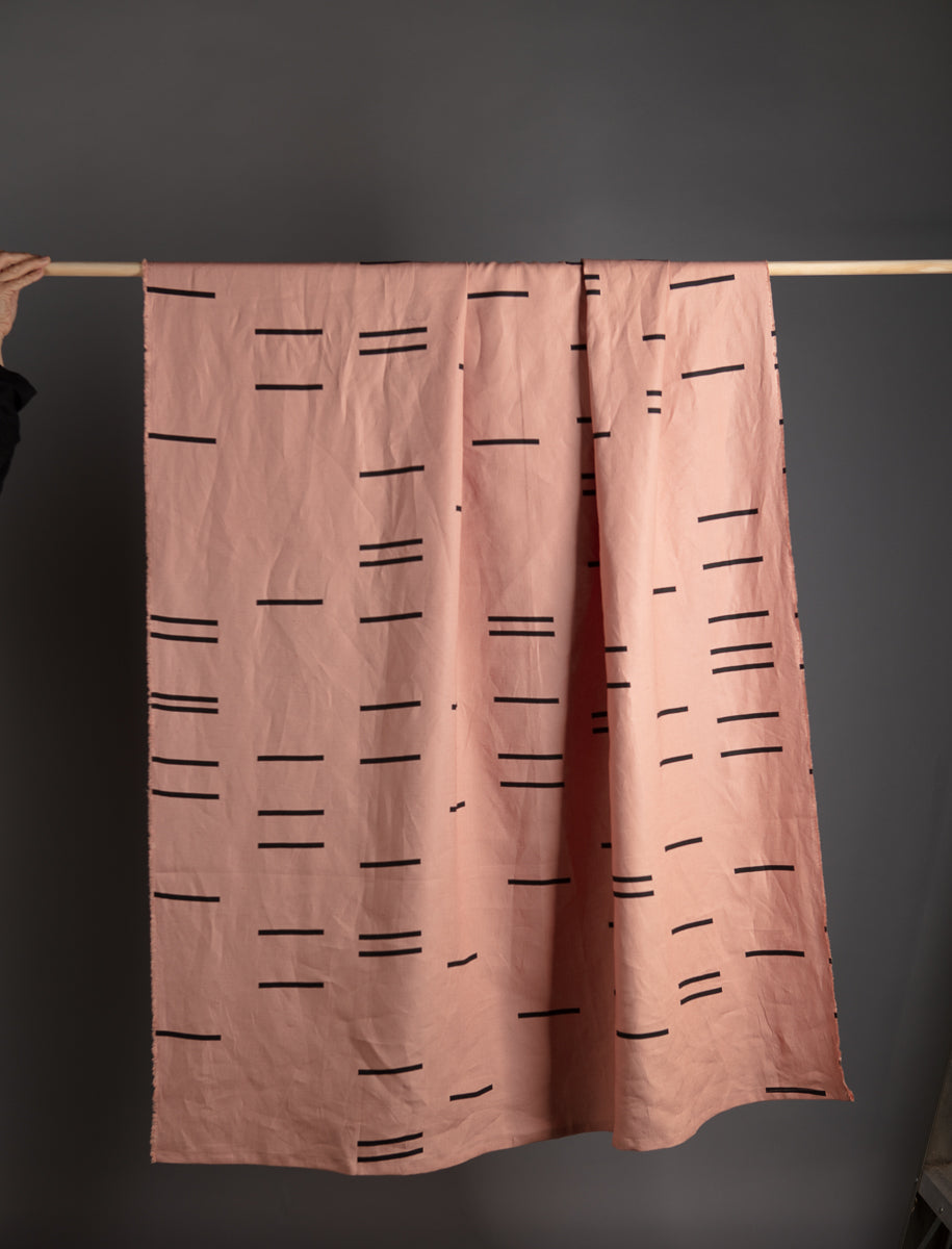 A folded linen throw with geometric patterns, highlighting its natural fibers and sustainable craftsmanship.