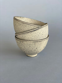 A stack of three handmade ceramic rice bowls. Made by Takashi Endo in a textural white glaze.