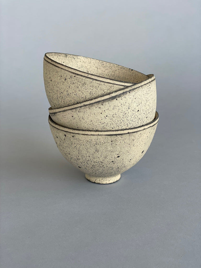 A stack of three handmade ceramic rice bowls. Made by Takashi Endo in a textural white glaze.