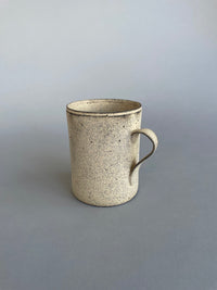 Side view of a generous-sized ceramic cup with unique handmade variations in shape and form.